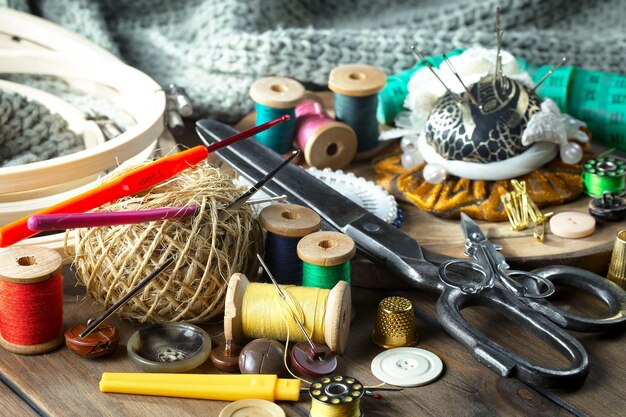 Photo une table avec diverses fournitures de couture, y compris une machine à coudre, une aiguille, une aiguille, une aiguille, une aiguille, une aiguille et une paire de boutons.