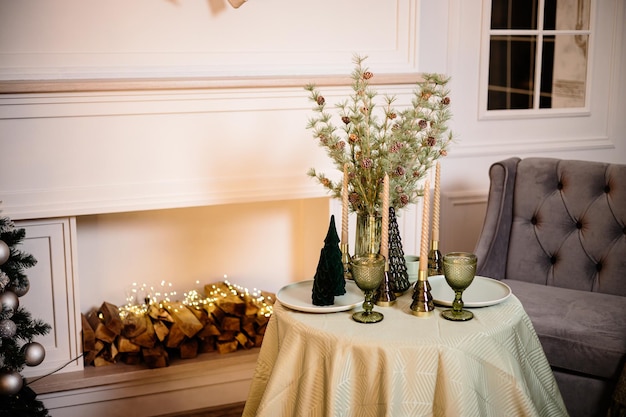 Une table dressée dans le salon près de la cheminée Ambiance romantique du Nouvel An au coin du feu Décoration intérieure du Nouvel An dans la maison