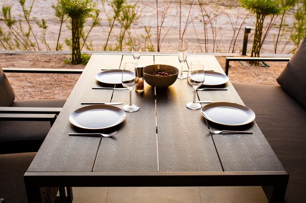 Table dressée pour quatre sur la terrasse d'étéTerrasse d'été entre amisDîner sur la terrasseEnsemble de table