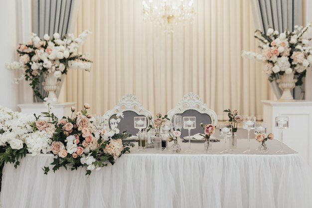 Une table dressée pour une réception de mariage avec un arrangement floral sur la table.