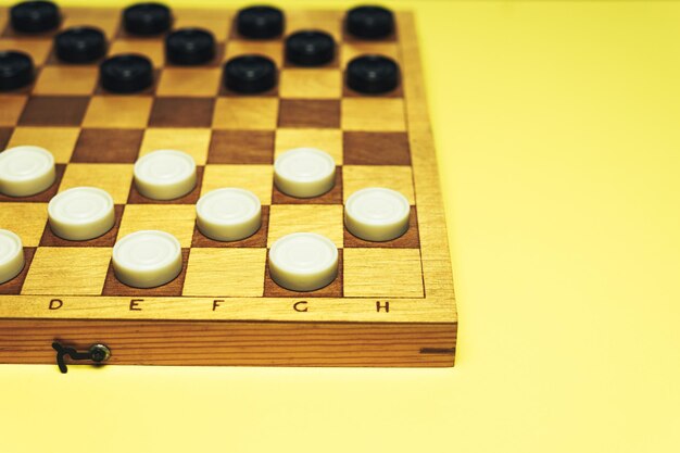 Photo table d'échecs avec des échecs sur un fond de table jaune