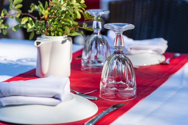 Table élégante avec fourchette, couteau, verre à vin, assiette blanche et serviette rouge au restaurant. Belle table à manger avec couverts et serviettes disposés pour le dîner, Turquie