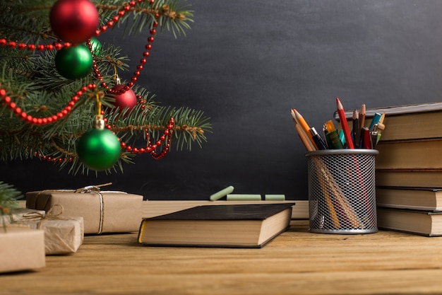 Table de l'enseignant avec des livres, un organisateur et un tableau