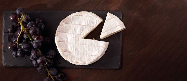 Photo table d'entrées avec camembert au fromage français et raisins pour l'apéritif buffet