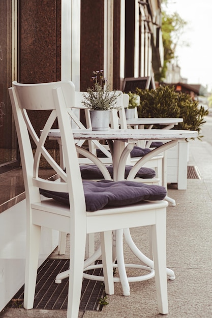 Table d'extérieur dans un café de rue Terrasse de café et de restaurant vide en plein air avec des tables et des chaises de plantes en pot dans le style indie et hipster de Londres Concept de voyage