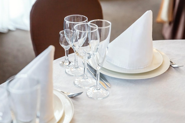 Table de fantaisie dressée pour le dîner avec des verres de serviette au restaurant de luxe fond intérieur mariage eleg