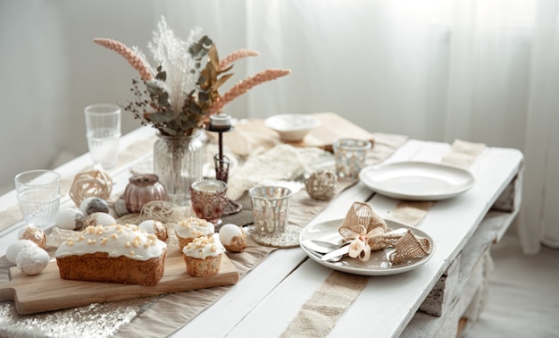 Une table de fête avec un cadre magnifique, des détails décoratifs, des œufs et un gâteau de Pâques