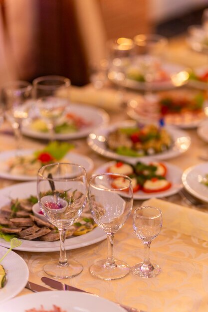 Photo table de fête avec des collations, des verres, des couverts et des serviettes pour un banquet.