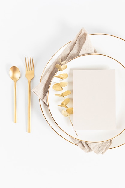 Table de fête avec couverts dorés et assiette en porcelaine