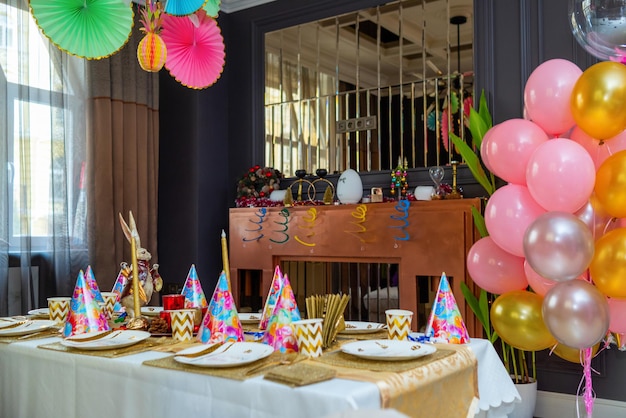 Table de fête avec décorations sur fond de ballons colorés