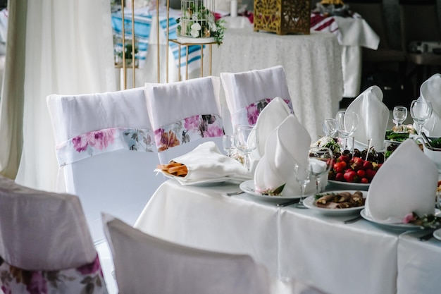 Table de fête avec de la nourriture recouverte d'une nappe décorée dans la salle de banquet de mariage