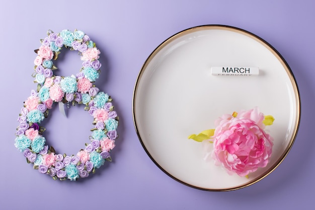 Table de fête Le numéro 8 décoré de fleurs sur une assiette blanche Félicitations pour la Journée internationale de la femme le 8 mars une bannière de carte postale festive