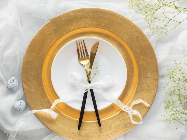 Table de fête de Pâques avec des oeufs et des fleurs sur fond blanc