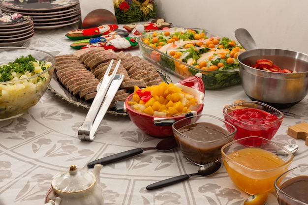 Une table de fête avec des plats froids et un dîner de noël fait maison coloré