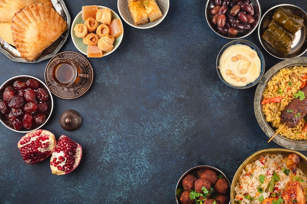 Table de fête Ramadan kareem Iftar avec assortiment de plats arabes traditionnels festifs, bonbons, dates. Grand repas du soir de l'Aïd al-Fitr moubarak, vue de dessus. Nourriture islamique de vacances, festin de Ramadan, espace pour le texte