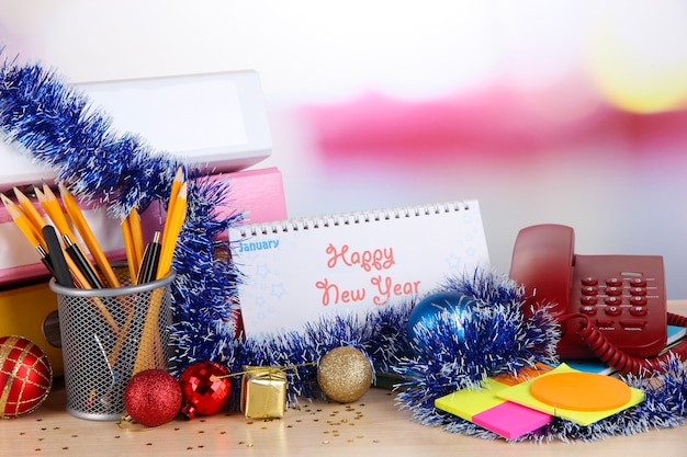 Table avec fournitures de bureau, calendrier et gros plan de guirlandes de Noël