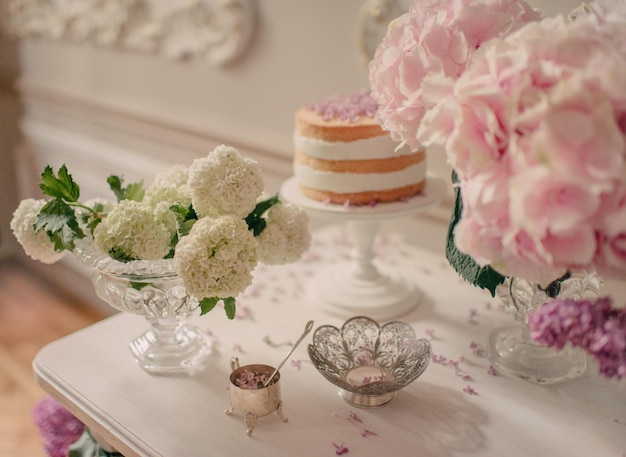 Une table avec un gâteau et des fleurs dessus