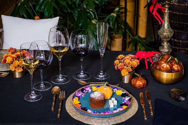 une table avec un gâteau et des verres de vin dessus