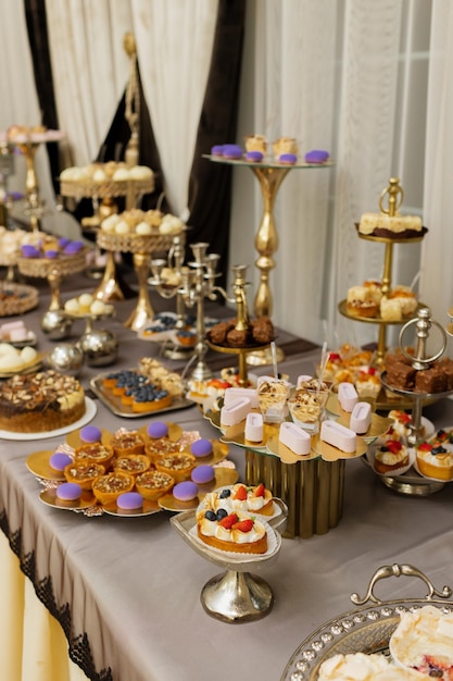Table avec gâteaux bonbons bonbons buffet Table de desserts pour une fête goodies pour le banquet de mariage Close up candy bar Délicieux décoré