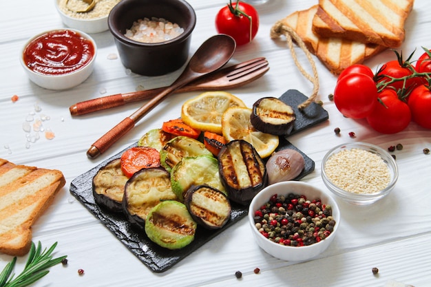 Table grillée végétarienne saine avec du pain et des légumes sans gluten (courgettes, aubergines, carottes, citron)