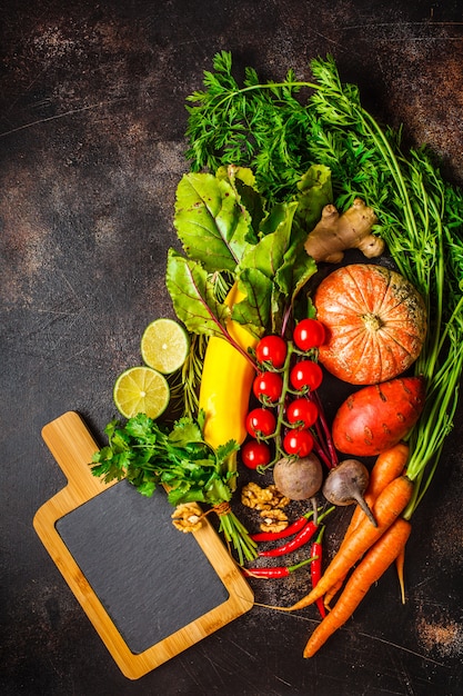 Table de légumes d'automne. Citrouille, courgettes, patates douces, carottes et betteraves sur une table sombre.