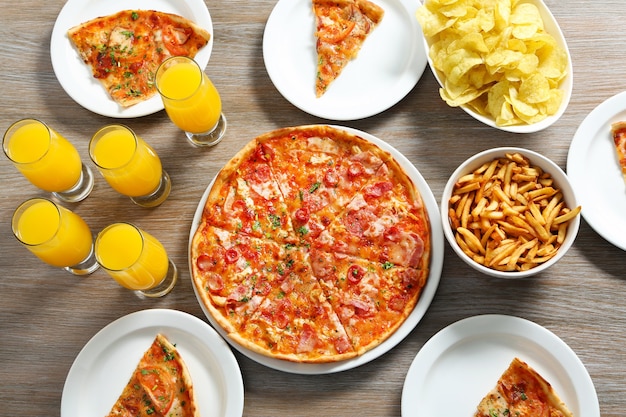 Table à la maison avec pizza et boissons pour amis