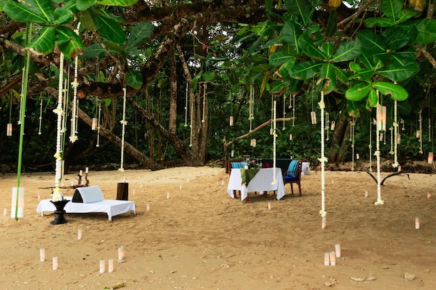 Table à manger dressée pour un rendez-vous romantique sur une plage de sable