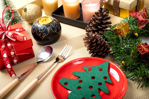 Une table à manger de Noël avec une assiette en céramique rouge vif.