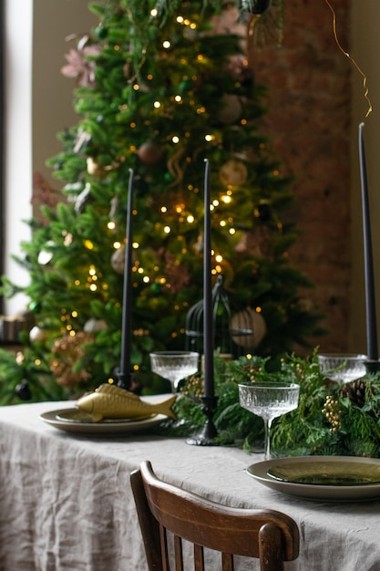 Une table à manger de noël décorée avec un sapin de noël