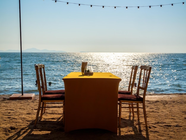 Table à manger avec quatre chaises sur la plage