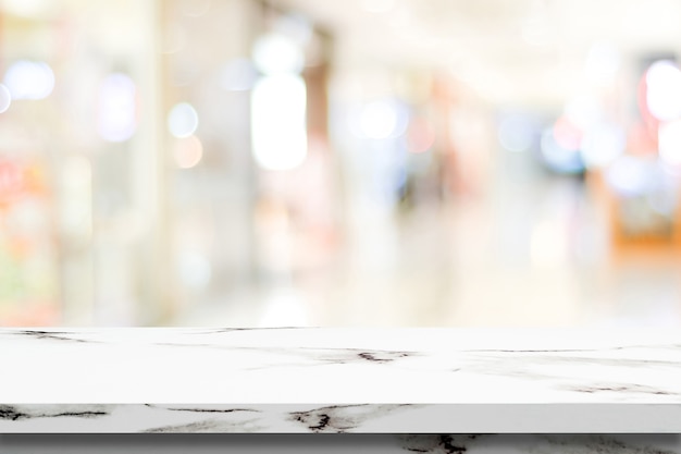 Table en marbre blanc vide sur fond de magasin de flou