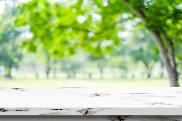 Table de marbre blanc vide sur fond de parc vert flou, montage de l&#39;affichage du produit