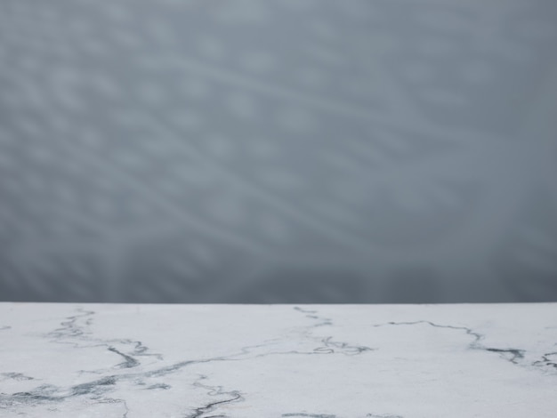 Table en marbre sur fond de mur en béton avec des ombres naturelles