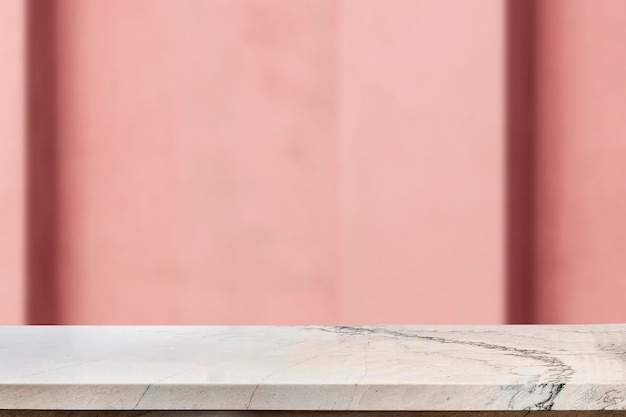 Table en marbre avec ombre sur fond de texture de mur rose, présentation du produit