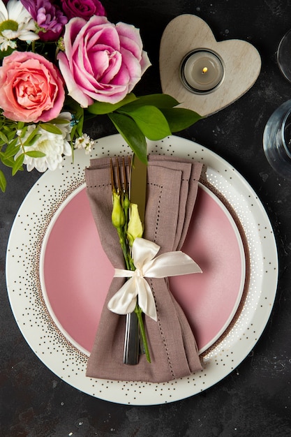 Table de mariage concept de réglage de la plaque de couverts sur serviette en lin et fleurs vue de dessus photo verticale