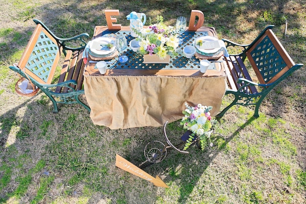 Table de mariage décorée rustique sur le terrain au coucher du soleil