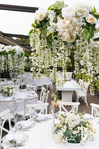 Table de mariage servie avec des fleurs blanches fraîches décoratives et des bougies Détails de la célébration