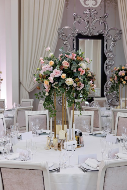 Photo table de mariage servie avec des fleurs blanches et roses décoratives bougies détails de la célébration