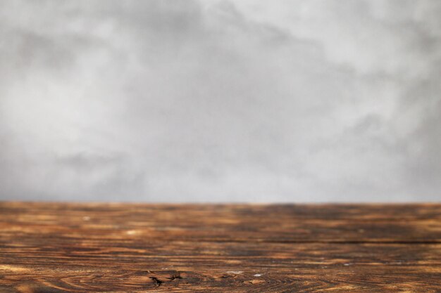 Table marron en bois vide sur un fond de fumée grise