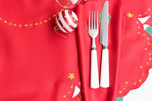 Table de Noël avec tissu rouge, décorations de Noël, couteau et fourchette