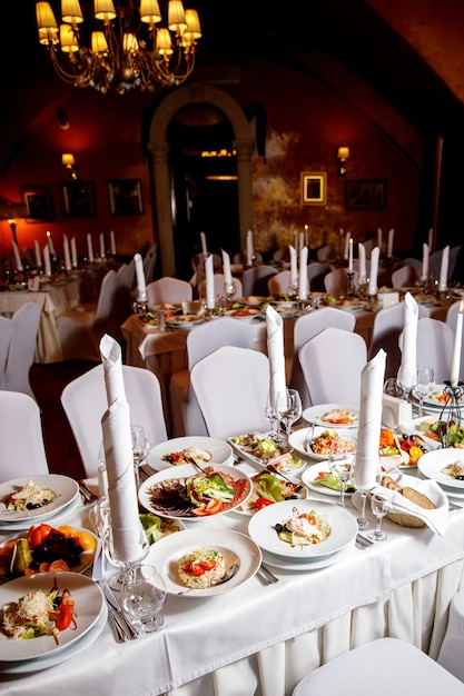 Table avec de la nourriture avant le banquet. Prêt pour la salle des invités.