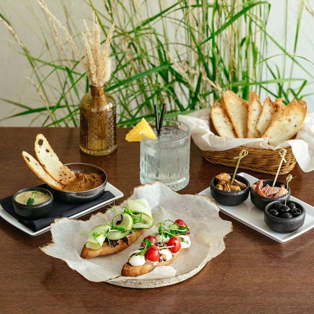 Une table avec de la nourriture et des boissons, y compris un sandwich et un verre d'eau.