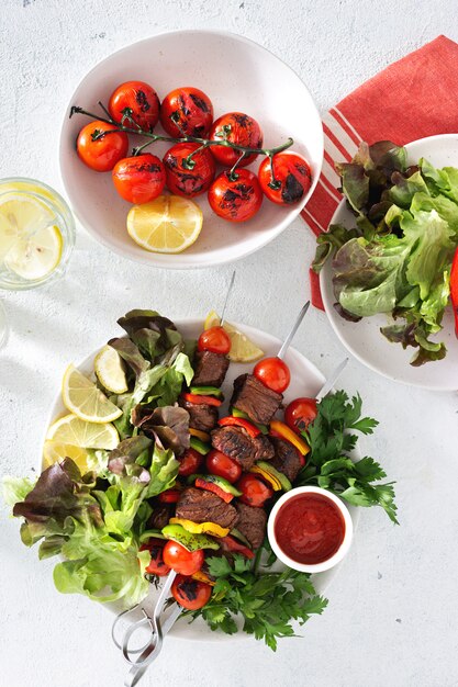 Table de nourriture avec brochette de viande de bœuf grillée avec légumes et sauce vue de dessus