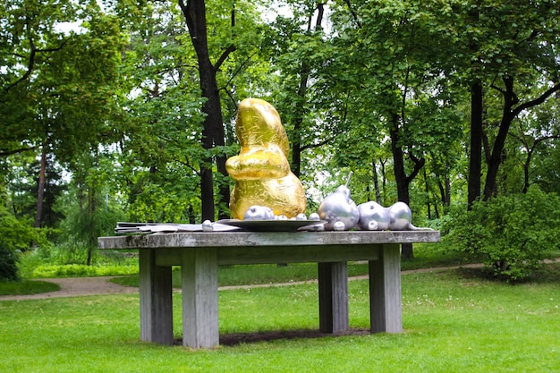 Une table avec un objet en or dessus et un tas de boules en argent dessus.