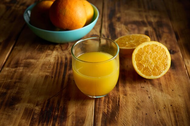 Table avec des oranges de jus d'orange coupées en deux et des oranges fraîches