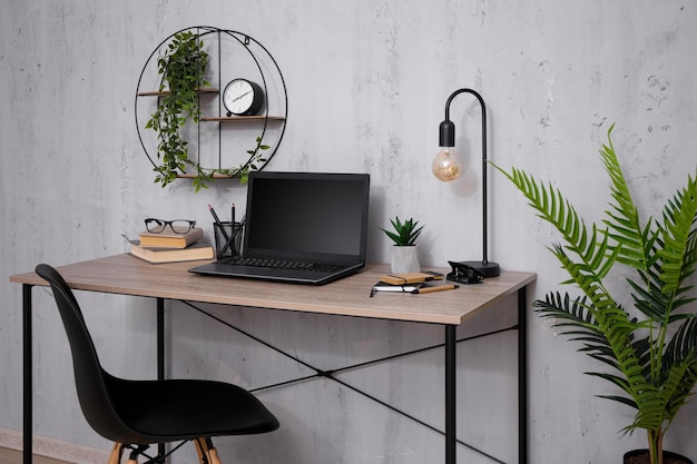 Table avec ordinateur portable au bureau sur mur de béton