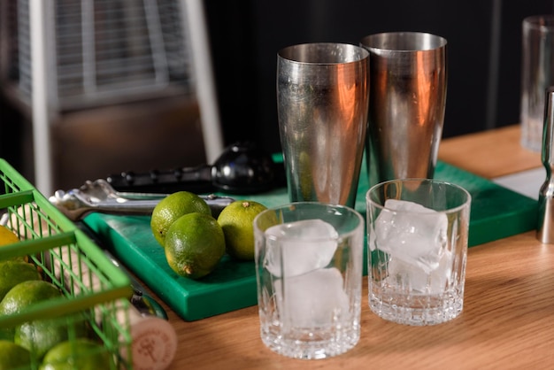 Table où le barman travaille avec des citrons shaker presse-agrumes et verre de glace