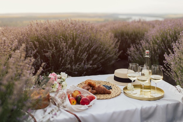 Une table avec un panier de nourriture et un champ de lavande en arrière-plan