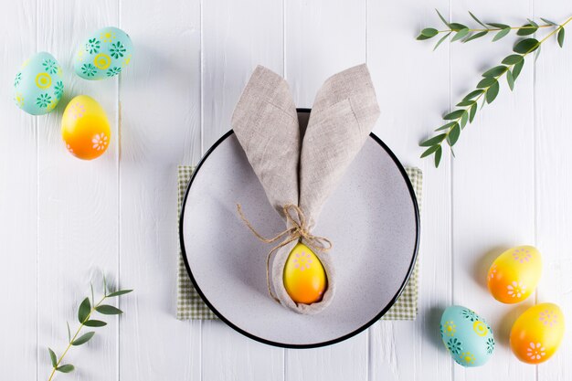 Table De Pâques Festive De Printemps Avec Serviette En Lin Oreilles De Lapin Et Couverts De Cuisine. Mise à Plat, Vue De Dessus.