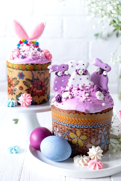 Photo table de pâques avec des gâteaux de pâques traditionnels, des œufs peints et des branches de fleurs